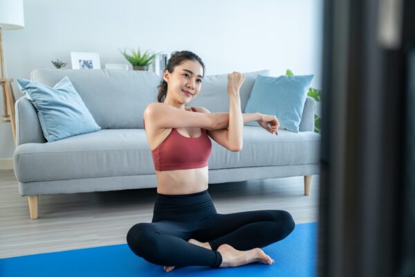 Asian young beautiful active woman doing Yoga Pilates workout at home.